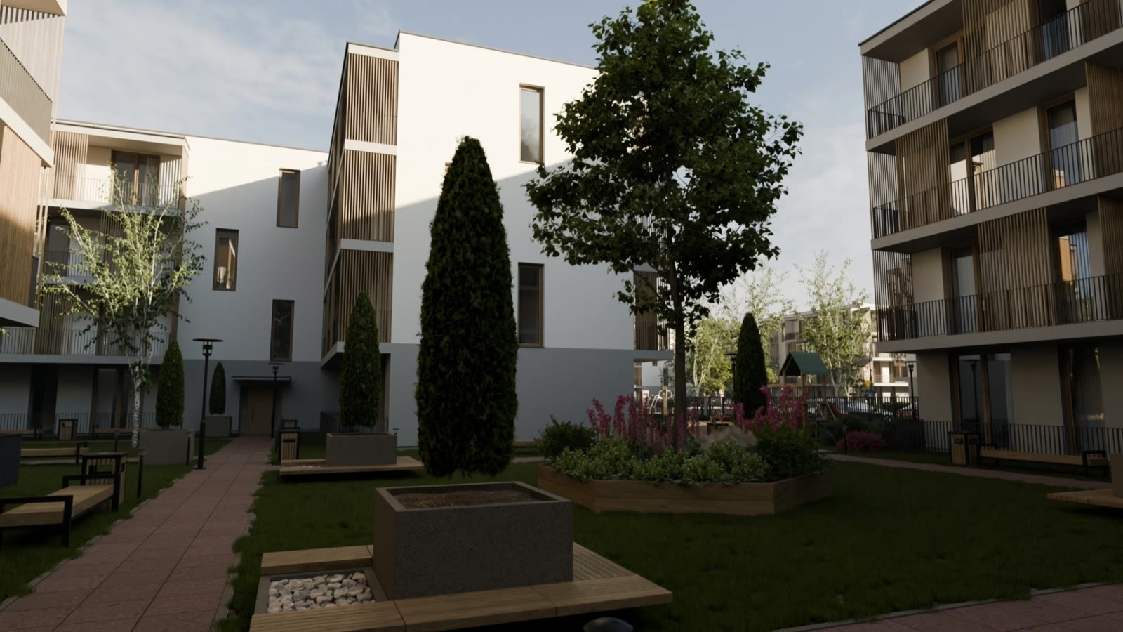 The courtyard garden between the buildings: lawn, trees, flower beds and wooden benches
